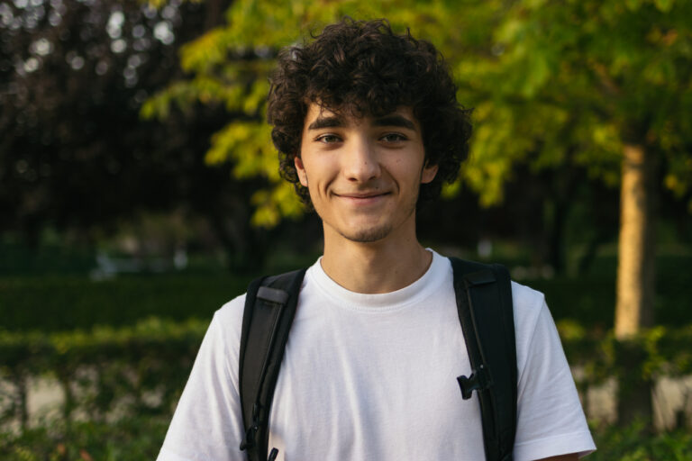 Portrait of young student man with curly hair
